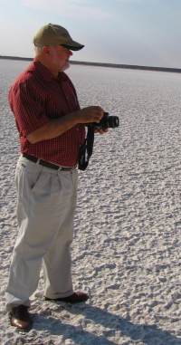 Ein Photograph auf einem ausgetrockneten Salzsee in Namibia Osten